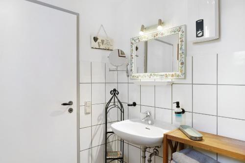 a white bathroom with a sink and a mirror at Zur Lupine in Bebra