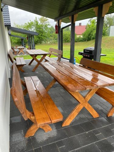 a wooden picnic table and chairs on a patio at Biebrzańska Przystań 7 in Goniadz
