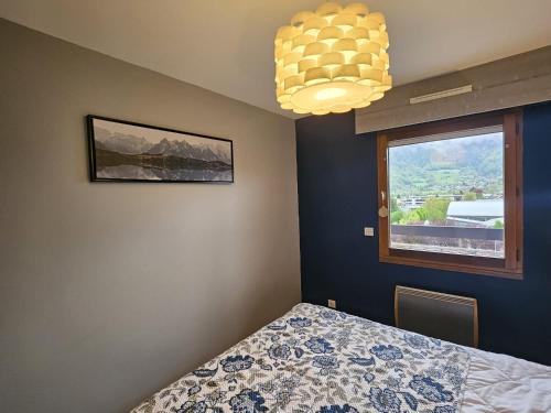 a bedroom with a bed and a window at Le Haut du Rosay in Sallanches