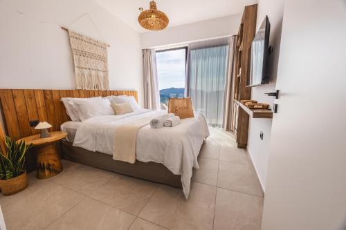 a bedroom with a bed and a large window at ELGIAN Luxury Villa -Private Pool & Sea View in Póndi