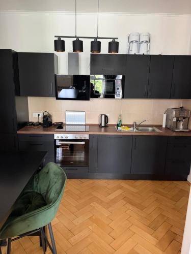 a kitchen with black cabinets and a laptop on a counter at Exklusives und stilvoll eingerichtetes Apartment für Erwachsene in Bad Liebenwerda