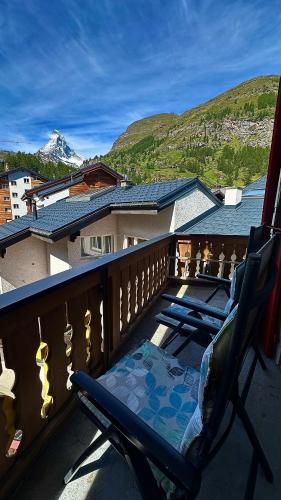 a balcony with a chair and a view of a mountain at Hotel Rhodania in Zermatt
