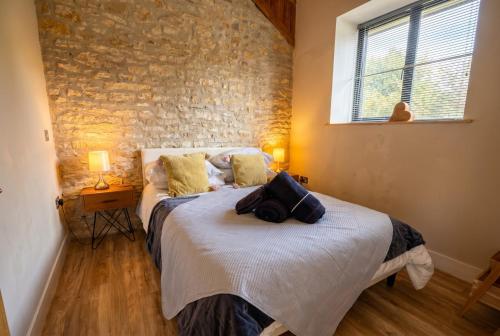 a bedroom with a bed and a brick wall at Lynwood Barn - Barn Conversion in Midsomer Norton, Parking & Dog Friendly in Radstock
