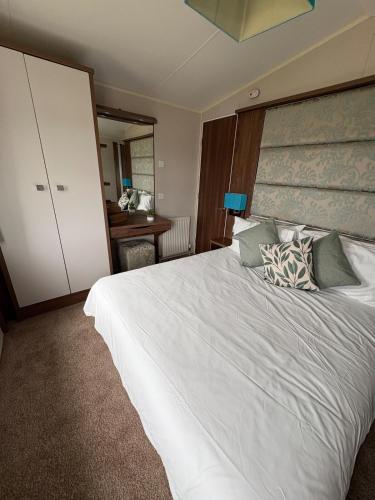 a bedroom with a large white bed and a desk at Skyline in Lossiemouth