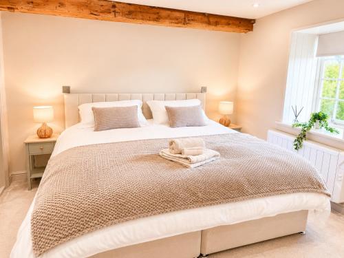 a bedroom with a large bed with a towel on it at Yarwell Mill in Nassington