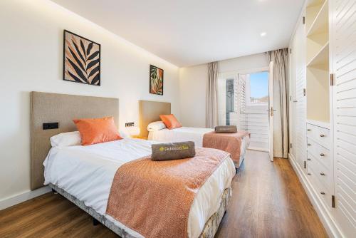 a bedroom with two beds and a window at Apartment Vistamar III in Port de Pollensa