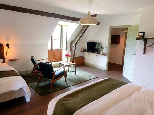 a bedroom with a bed and a desk and a tv at La Valaisienne in Val Couesnon