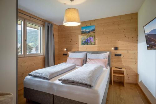 a bedroom with a bed in a room with wooden walls at Appartement Carmen in Uderns