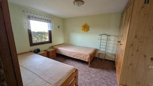 a bedroom with two beds and a window and a ladder at Ferienhaus am Wald in Augsburg