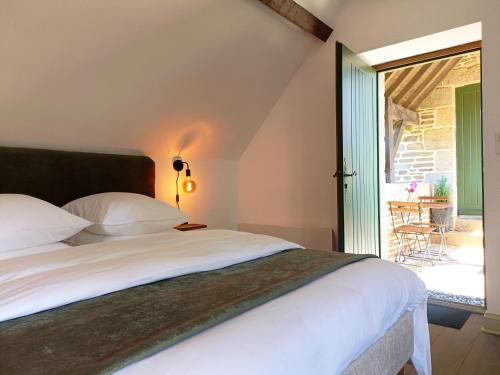 a bedroom with a bed and a sliding glass door at La Valaisienne in Val Couesnon