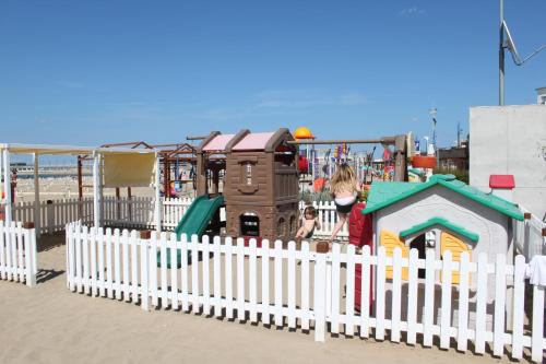 a playground on the beach with a white fence at Park Hotel Cattolica & Restaurant in Cattolica