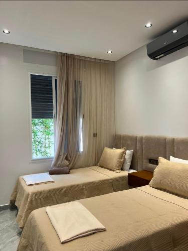 a hotel room with two beds and a couch at villa la perle in Asilah