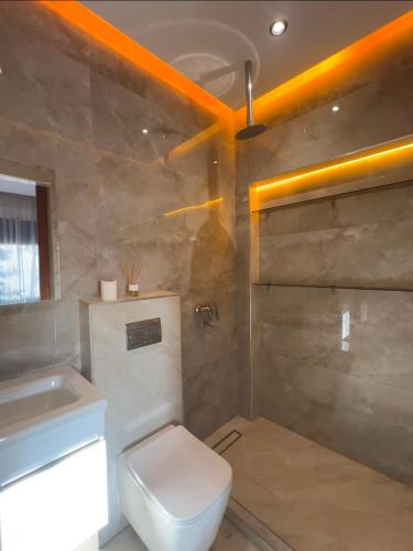 a bathroom with a white toilet and a sink at villa la perle in Asilah