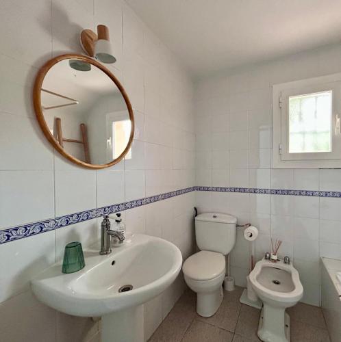 a bathroom with a sink and a toilet and a mirror at Ca sa Madona Hostal in Paguera