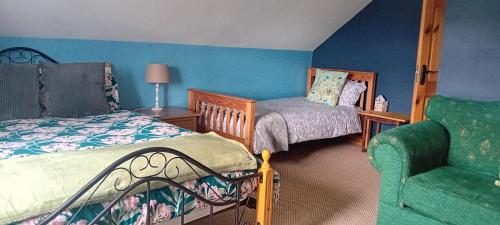 a bedroom with two beds and a green chair at Lakeview in Fenagh