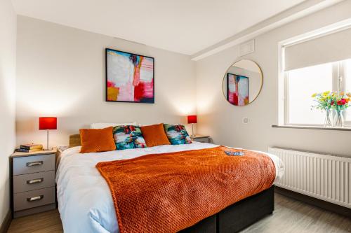 a bedroom with a bed with an orange blanket at Clanbrassil Townhouse in Dundalk