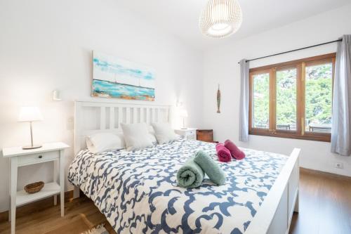 a white bedroom with a bed and a window at Casita Sa Calobra in Cala Tuent