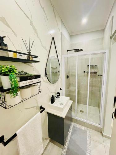a bathroom with a sink and a shower and a mirror at Cozy and Warm-Private Queen Bedroom with Private Bathroom & shared Kitchen& Lounge in Parklands