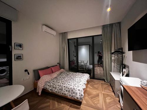 a bedroom with a bed and a desk and a television at A&D Studio in Klíma