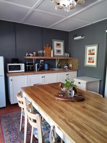 a kitchen with a large wooden table in a room at De Oude Schuur in Stellenbosch
