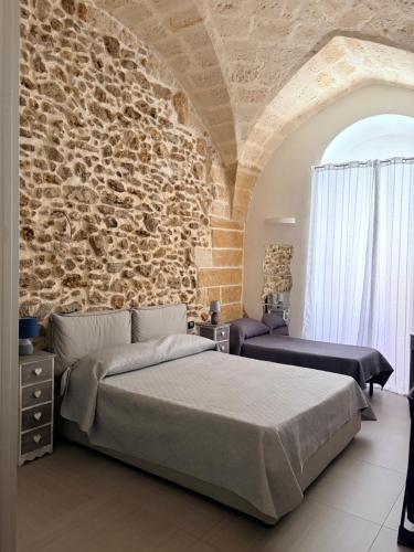 a bedroom with a bed and a stone wall at Casa vacanze G&G in Brindisi