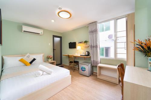 a bedroom with a bed and a desk and a window at Ngân Hà Bouitque Apartment-Hotel in Ho Chi Minh City