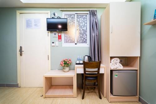 a small kitchen with a small desk and a table with a chair at Ngân Hà Bouitque Apartment-Hotel in Ho Chi Minh City