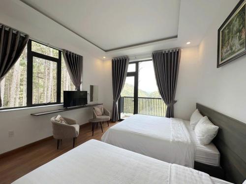 a hotel room with two beds and a television at Mimosa Forest Hotel Villa in Xuan An