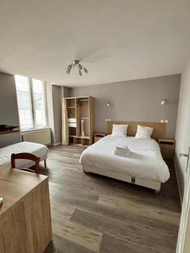 a hotel room with two beds and a table at Le Lion D'or in Ouroux