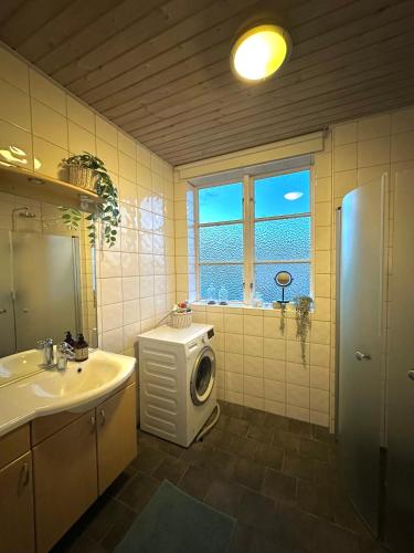 a bathroom with a sink and a washing machine at Våning Margareta in Kalmar