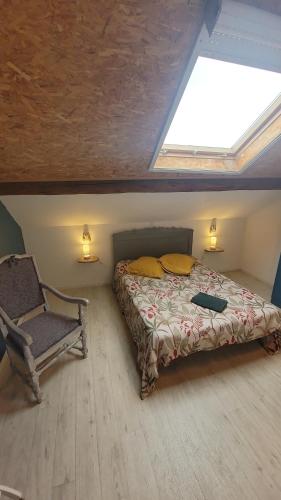 a bedroom with a bed and a chair in a attic at Gîtes & Chambres d'hôtes Villa La Lorraine in Folkling