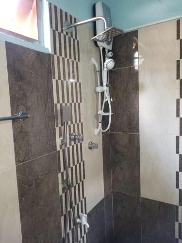 a shower with a shower head in a bathroom at Green Gardens in Weligama