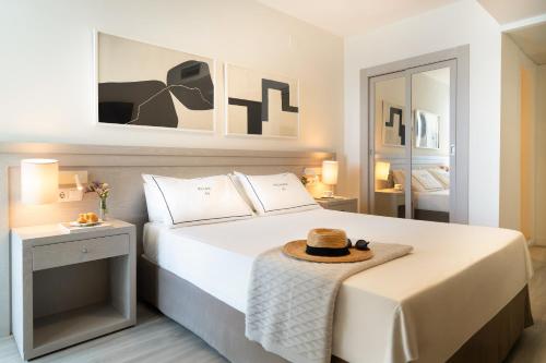 a bedroom with a bed with a hat on it at Hotel Helios Costa Tropical in Almuñécar