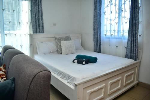a bed in a room with a pillow and a controller on it at Oceanic Homes in Mombasa