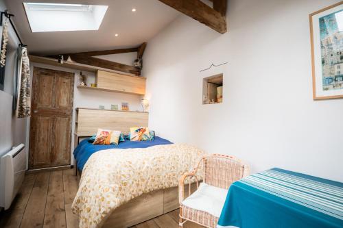 a bedroom with a bed with a blue comforter at P'tite Maizoun - Gîte in Hermanville-sur-Mer