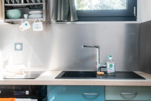 a kitchen counter with a sink and a window at P'tite Maizoun - Gîte in Hermanville-sur-Mer