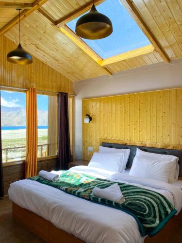 a bedroom with a large bed with a large window at Falcon'S Cottages in Meruk