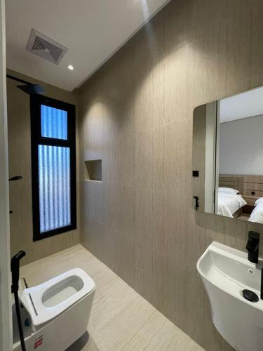a bathroom with a toilet and a sink and a mirror at شقة O&Me الفندقية in Medina