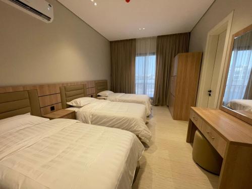 a hotel room with three beds and a window at شقة O&Me الفندقية in Medina