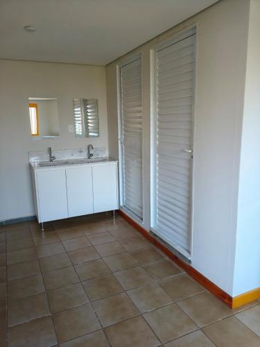 a bathroom with a sink and a mirror at Flats Rio Branco in Uberaba