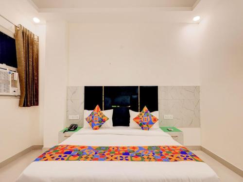 a bedroom with a large white bed with colorful pillows at Hotel Paradise Palace in Ghaziabad