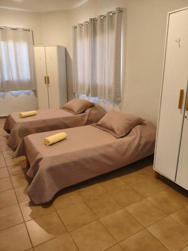 two beds sitting in a room with curtains at Flats Rio Branco in Uberaba
