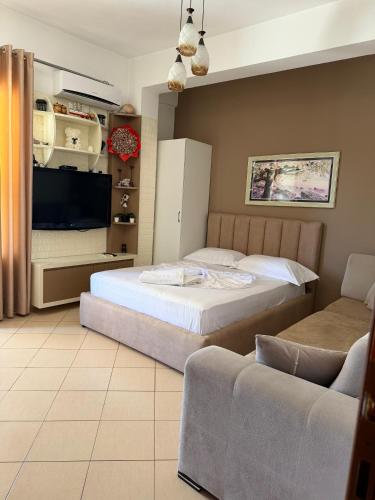 a bedroom with two beds and a tv and a couch at Eid Mar in Vlorë