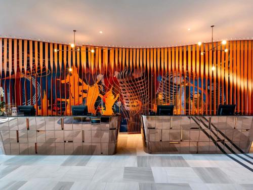 a lobby with a large mural on the wall at ibis Styles Bangkok Ratchada in Bangkok