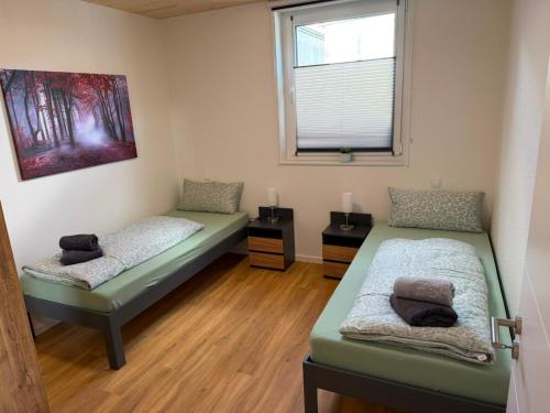 a room with two beds and a window at Haus Bahnhofsblick in Ottersberg