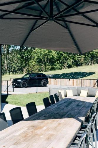a table and chairs with a car in the background at Villa de Luxe à Malmedy pour 14 personnes en Ardenne in Malmedy