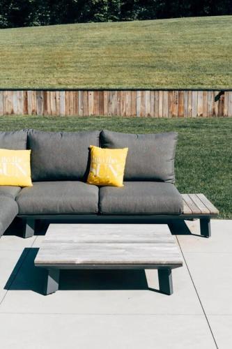 a couch with yellow pillows sitting on a patio at Villa de Luxe à Malmedy pour 14 personnes en Ardenne in Malmedy