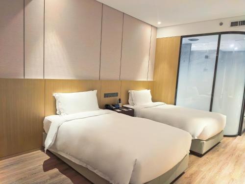 two beds in a hotel room with two beds sidx sidx sidx at Wyndham Shanghai Pudong in Shanghai