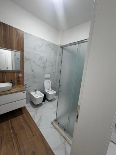 a bathroom with a shower and a toilet and a sink at Alison Guest House in Durrës