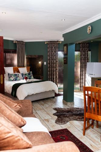 a living room with two beds and a couch at Big 5 Guest House Witbank in eMalahleni